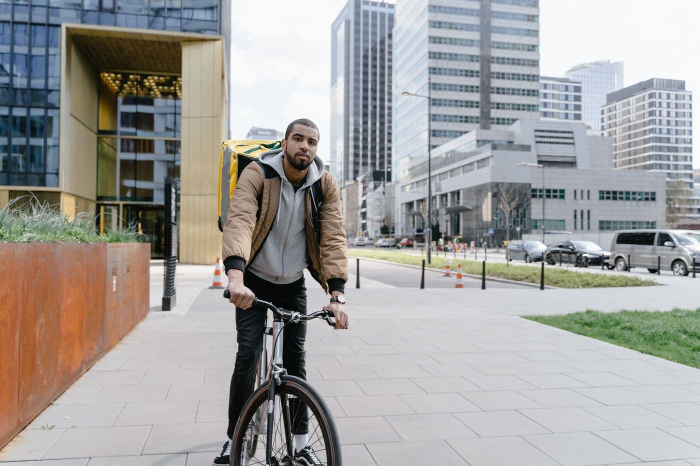 Repartidor de MandeYa con mochila térmica, en bicicleta por la ciudad